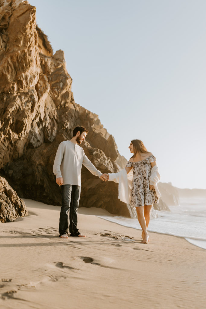 couple holding hands at the California beach in Big Sur