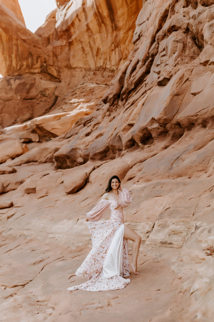 Girl modeling in the dress at her dress at the Arches National Park 