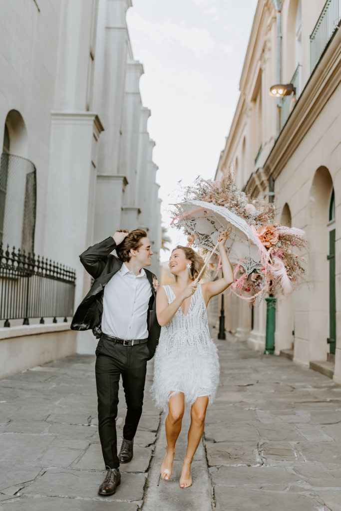 couple in Great Gatsby inspired clothes running on the streets of NOLA
