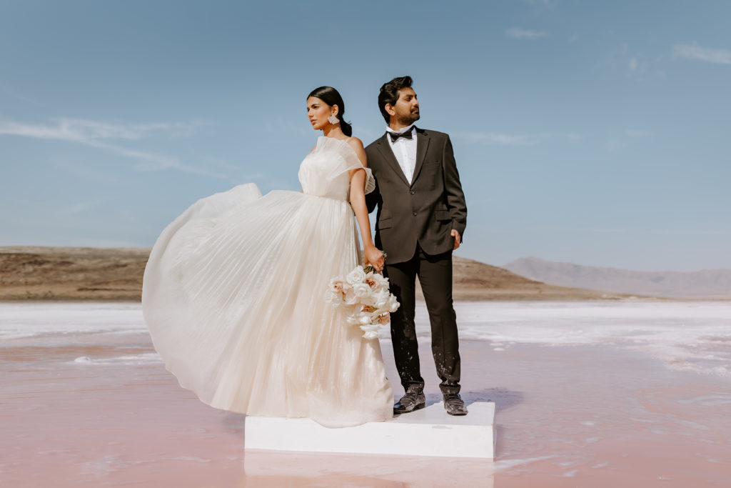 Indian couple standing side by side in the pink lake 