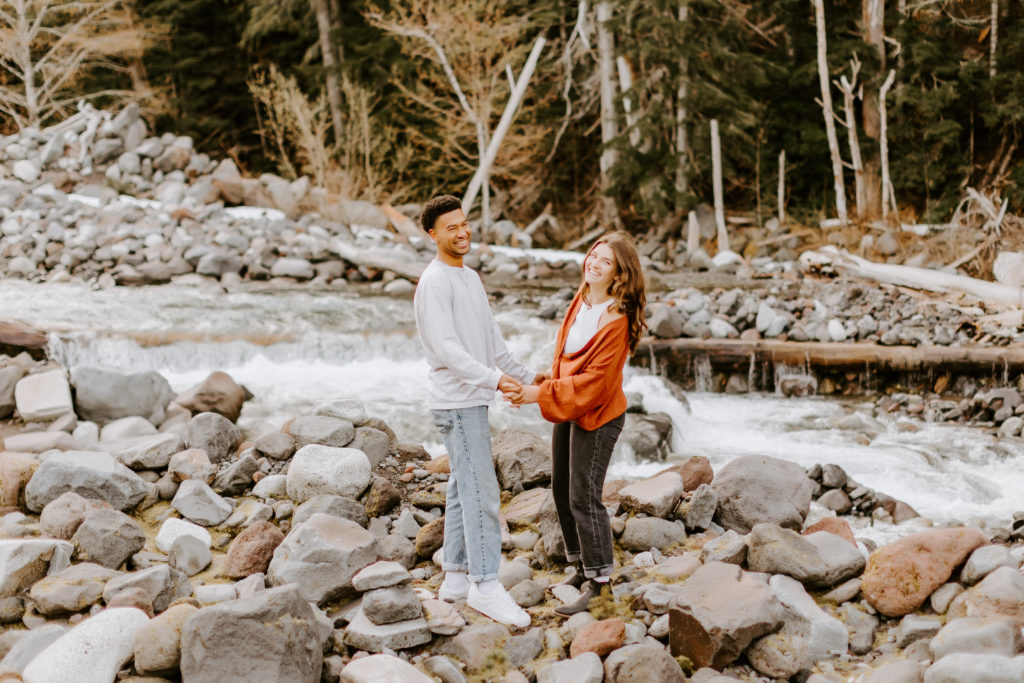 fun couple smiling holding hands at the Mt. Rainier park