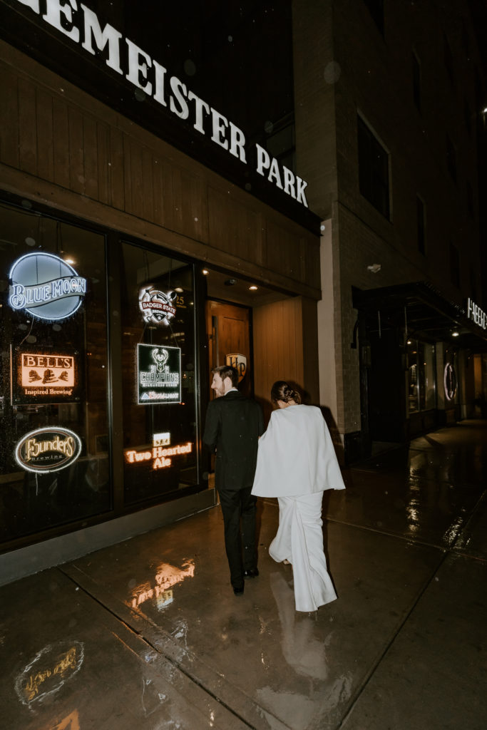 Wedding couple walking in the rain to the bar