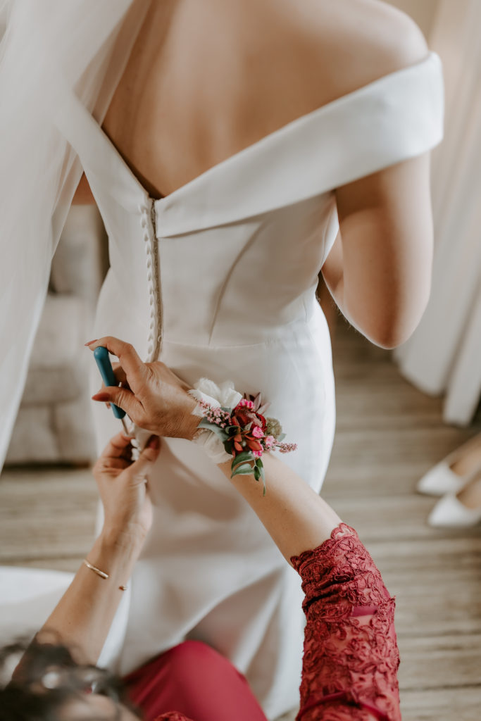 Bride's mom is using crochet hook on the wedding dress