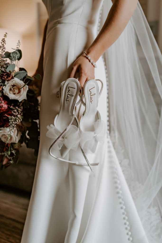 Bride is holding lulus wedding shoes