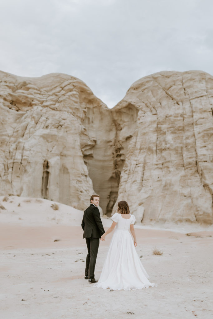 wedding couple walking to the heart shape stone at the Toadstools in Utah