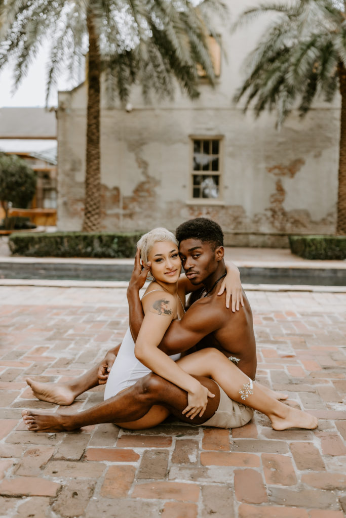 black couple sitting facing each other by the pool