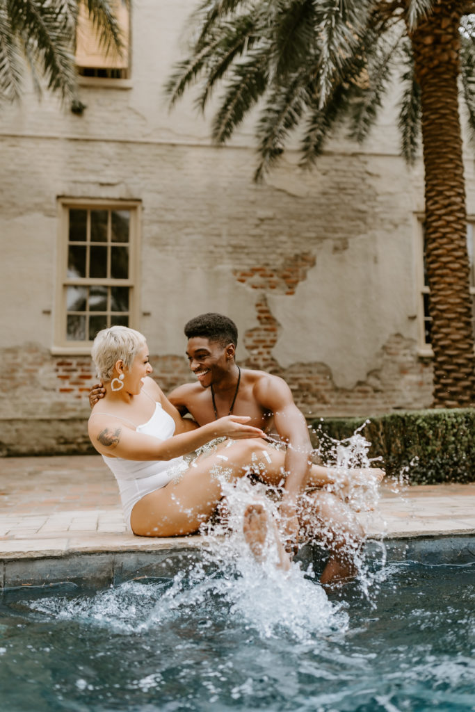 black couple playing water in the swimsuits by the pool in Jamaica