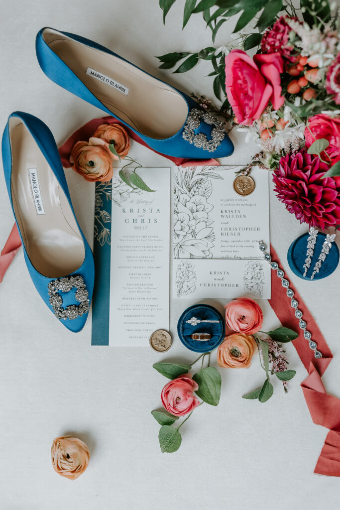 spring colors flowers with blue shoes, wedding invitations and wedding ring flat lay